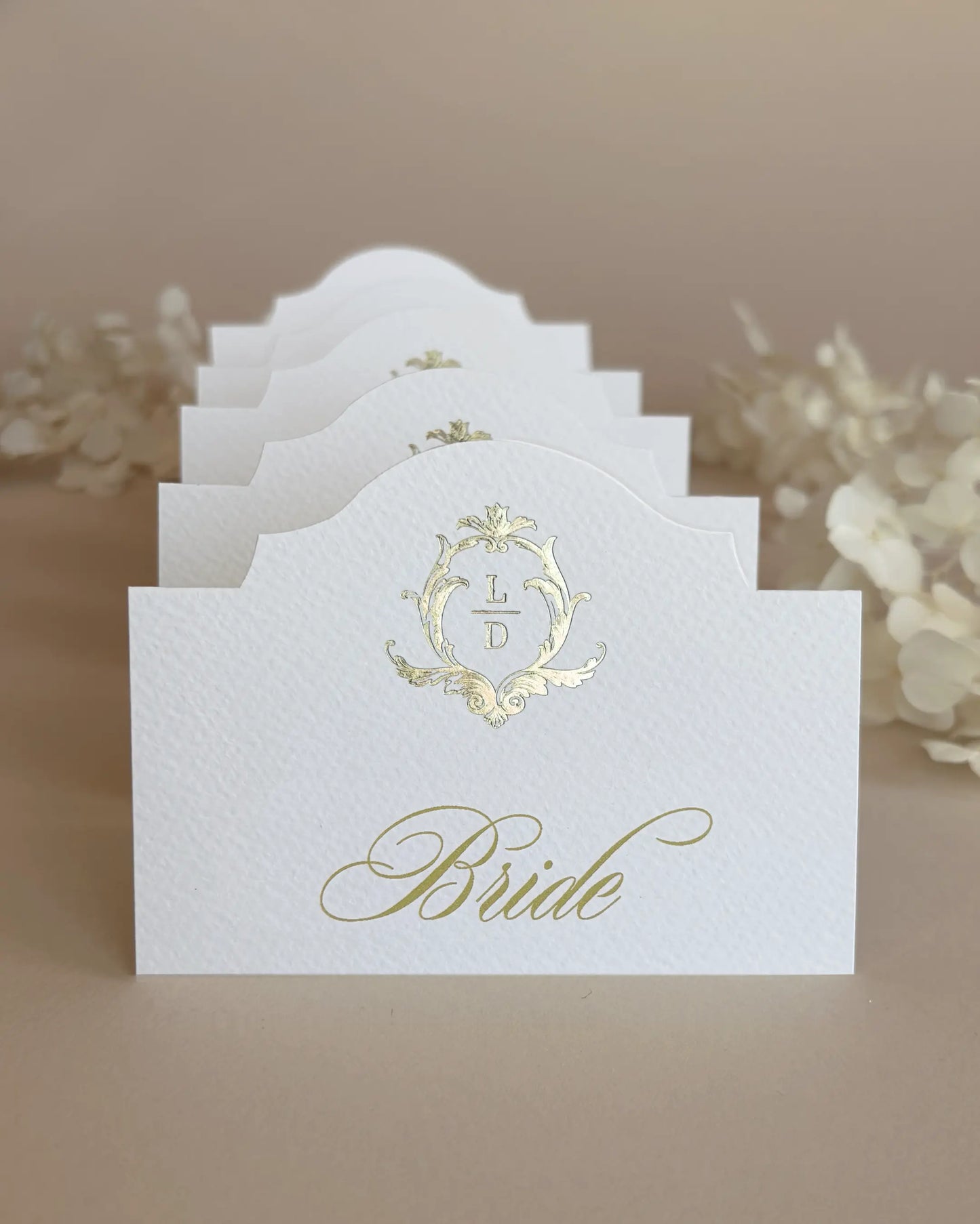 White Elegant Arch Place Cards with gold foil crest stacked in a row showing arch silhouette — Polina Perri