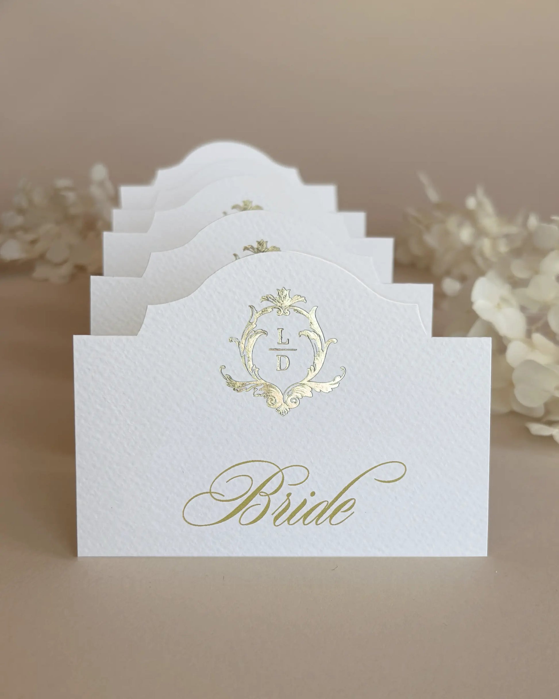 White Elegant Arch Place Cards with gold foil crest stacked in a row showing arch silhouette — Polina Perri