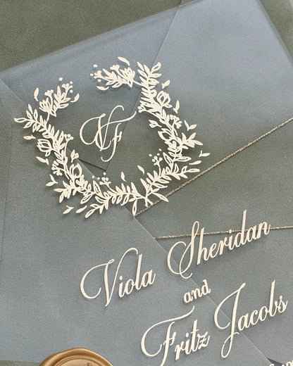 Fiori Acrylic Wedding Invitation close-up with white foil botanical wreath and script calligraphy names — Polina Perri