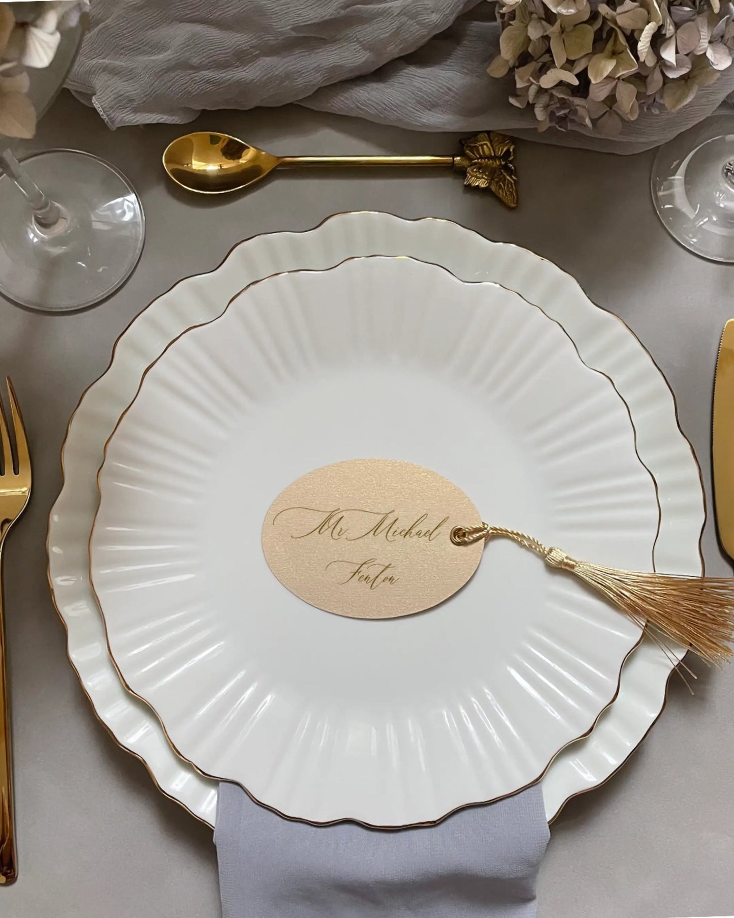 Cream Oval Place Card with gold tassel on white scalloped plate in a wedding table setting — Polina Perri