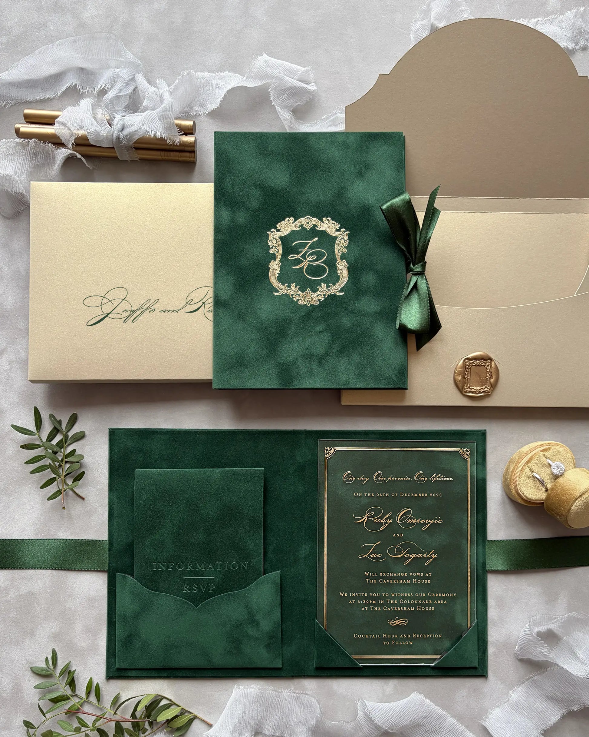 forest green wedding invitation set with gold accents on a textured surface