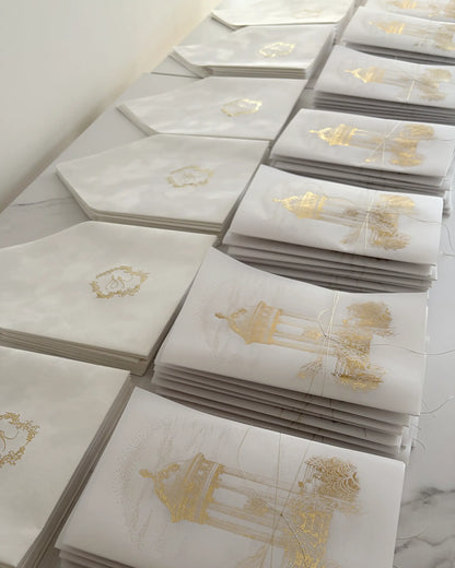 Luxury destination wedding invitations handcrafted stationery sets neatly arranged with gold foil vellum wraps and monogrammed envelopes Polina Perri