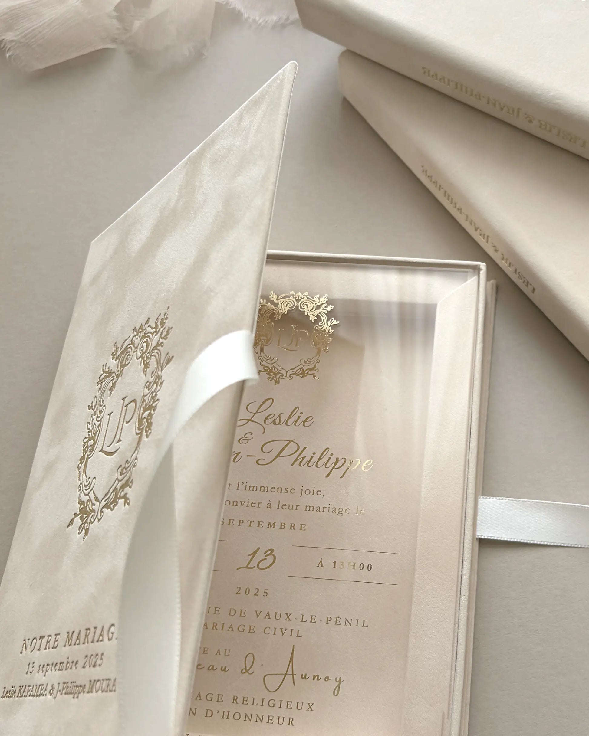 Opening a luxury blush velvet wedding invitation box to reveal a premium clear acrylic card with elegant gold lettering and white satin ribbon — Polina Perri