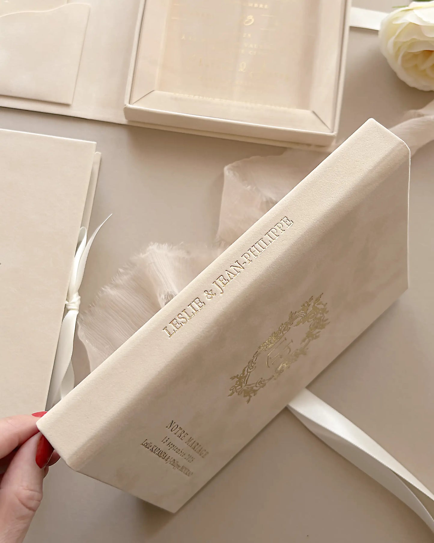 Side view of Vienna blush velvet boxed wedding invitation showing custom gold foil embossed names on the elegant spine — Polina Perri