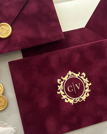 Burgundy velvet envelope with gold foil monogram crest close-up — Polina Perri