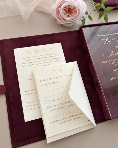 Close-up of the internal shaped pocket of a burgundy velvet invitation box, housing ivory gold foil pressed wedding response RSVP cards — Polina Perri