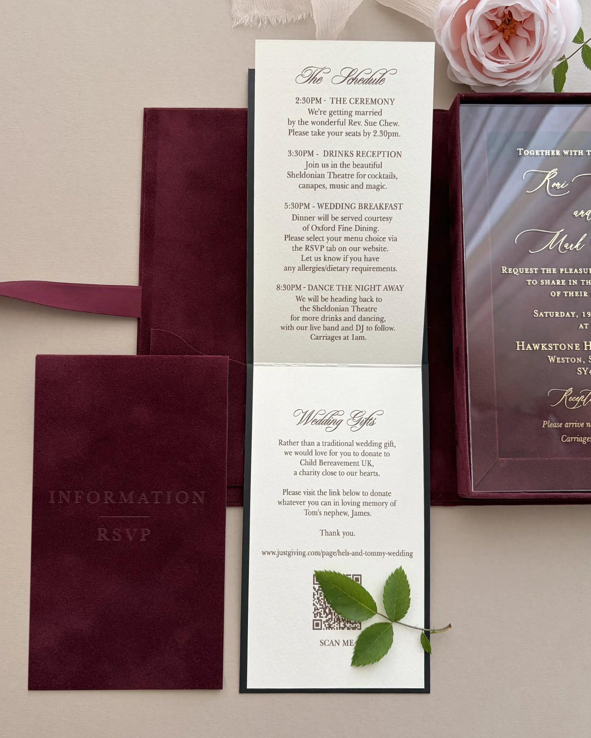 An unfolded ivory guest information booklet attached to a burgundy velvet wedding suite, detailing the schedule and wedding gifts with fine script typography — Polina Perri