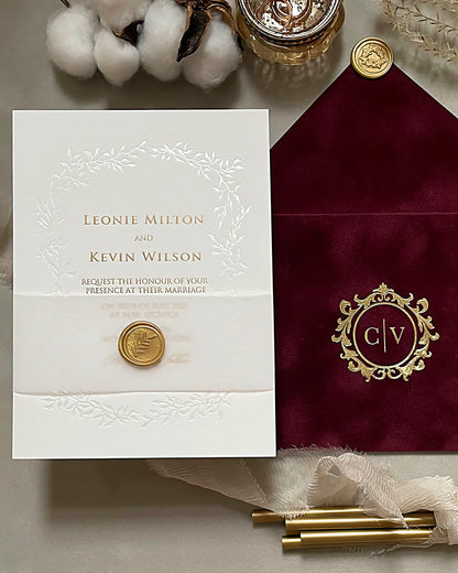 Luxury Celeste wedding invitation with brilliant gold foil stamping next to a rich burgundy velvet envelope featuring a custom gold foil monogram — Polina Perri