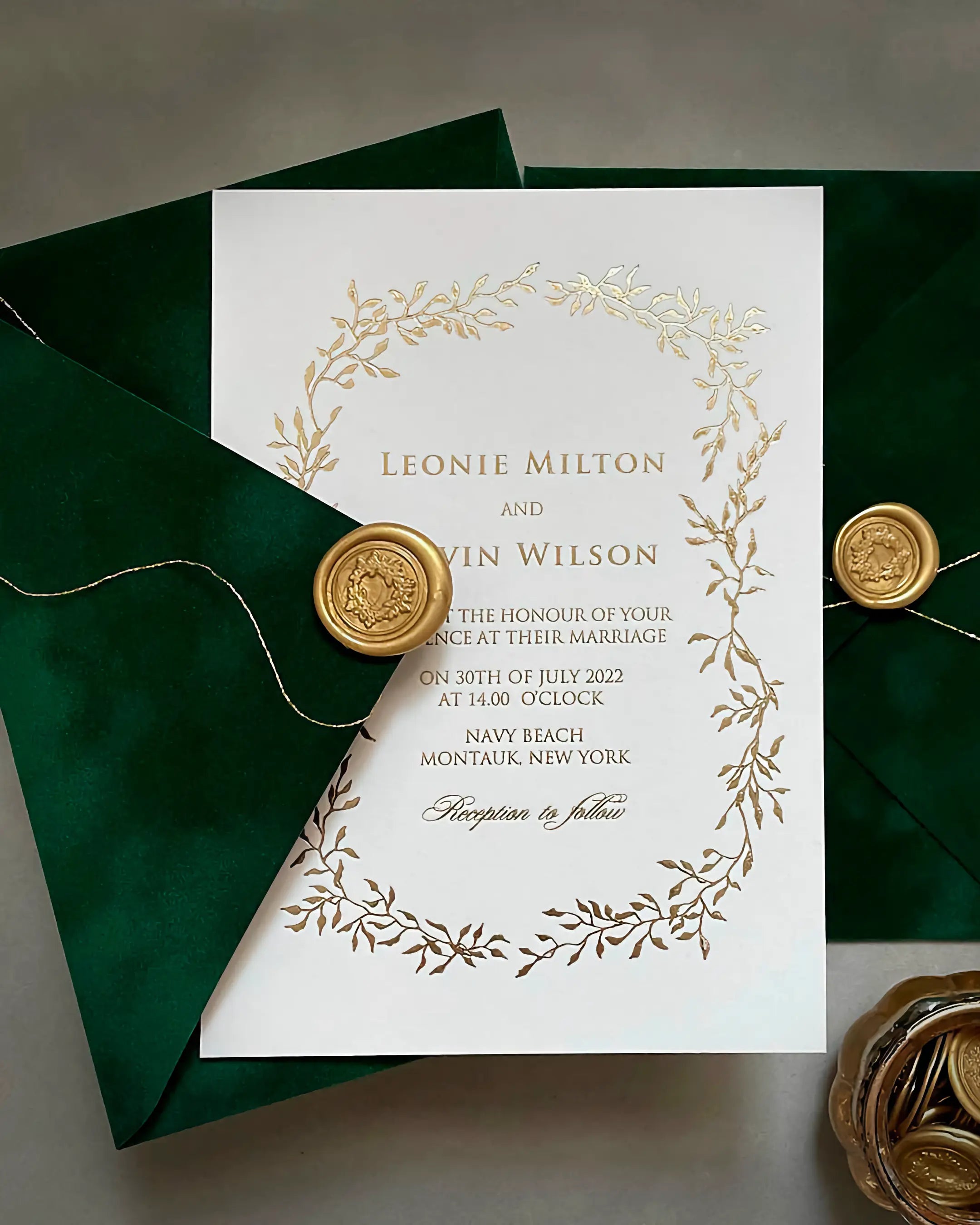 Celeste Gold foil pressed wedding invitation with an elegant botanical foliage frame on thick white cotton card stock, paired with a forest green velvet envelope and gold wax seal — Polina Perri