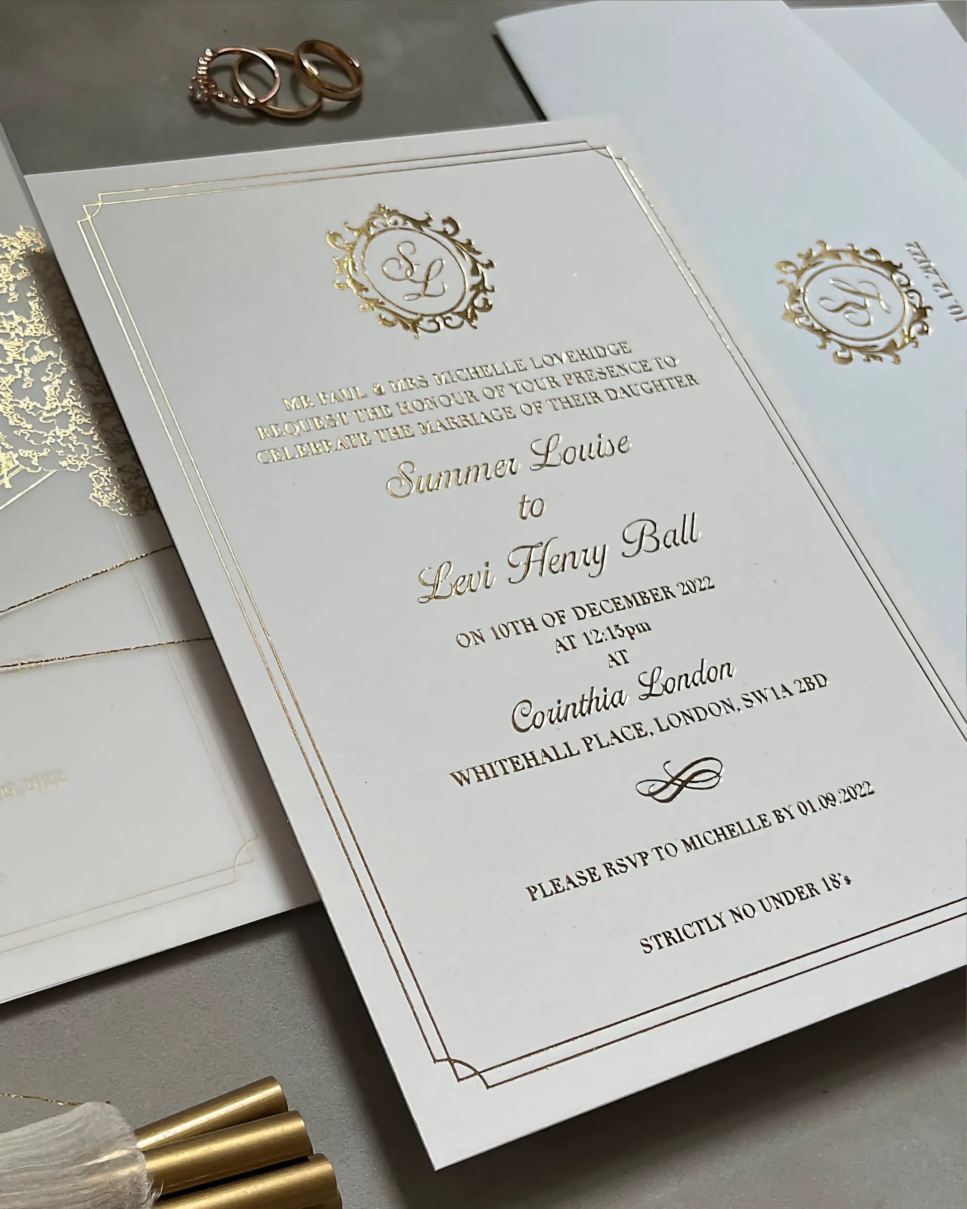 Close-up of the Corinthia luxury wedding invitation card featuring crisp gold foil pressed typography and a custom crest on heavy white cotton stock — Polina Perri