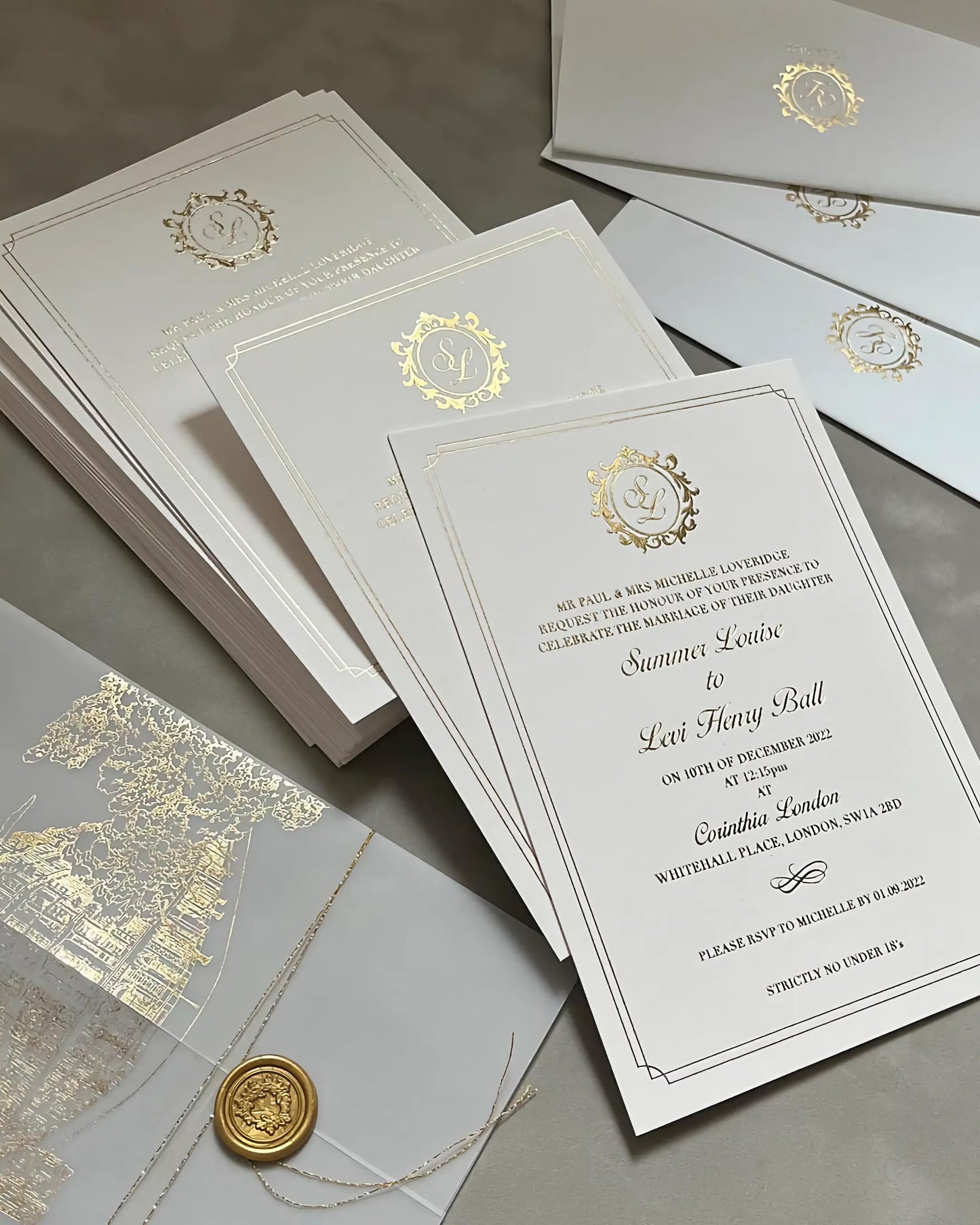 Luxury Corinthia wedding stationery suite with gold foil venue illustrations, vellum jackets, and premium white envelopes printed with elegant gold monograms — Polina Perri