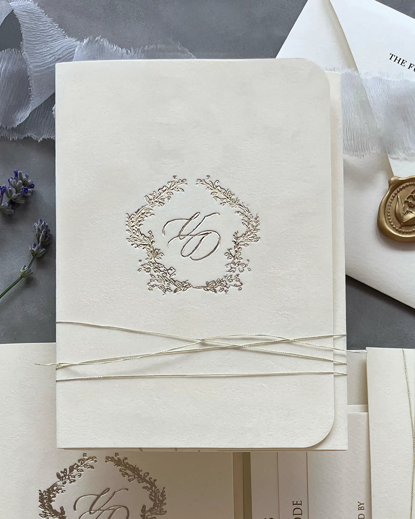 Virginie Cream velvet pocketfold wedding invitation with foil monogram wreath and gold string — Polina Perri