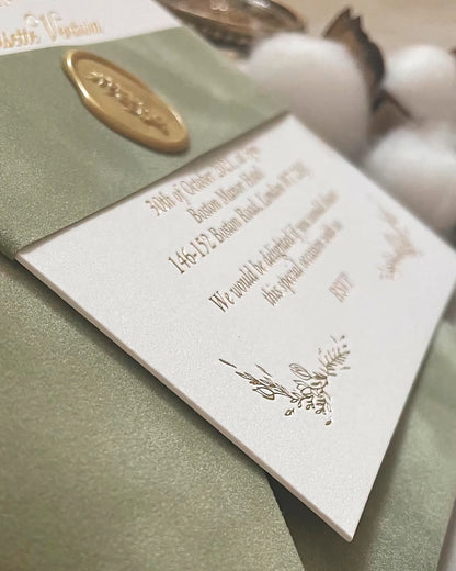 Close-up perspective of the Fiori wedding invitation card showing the crisp gold foil stamped text and a premium gold wax seal on heavy cotton stock — Polina Perri