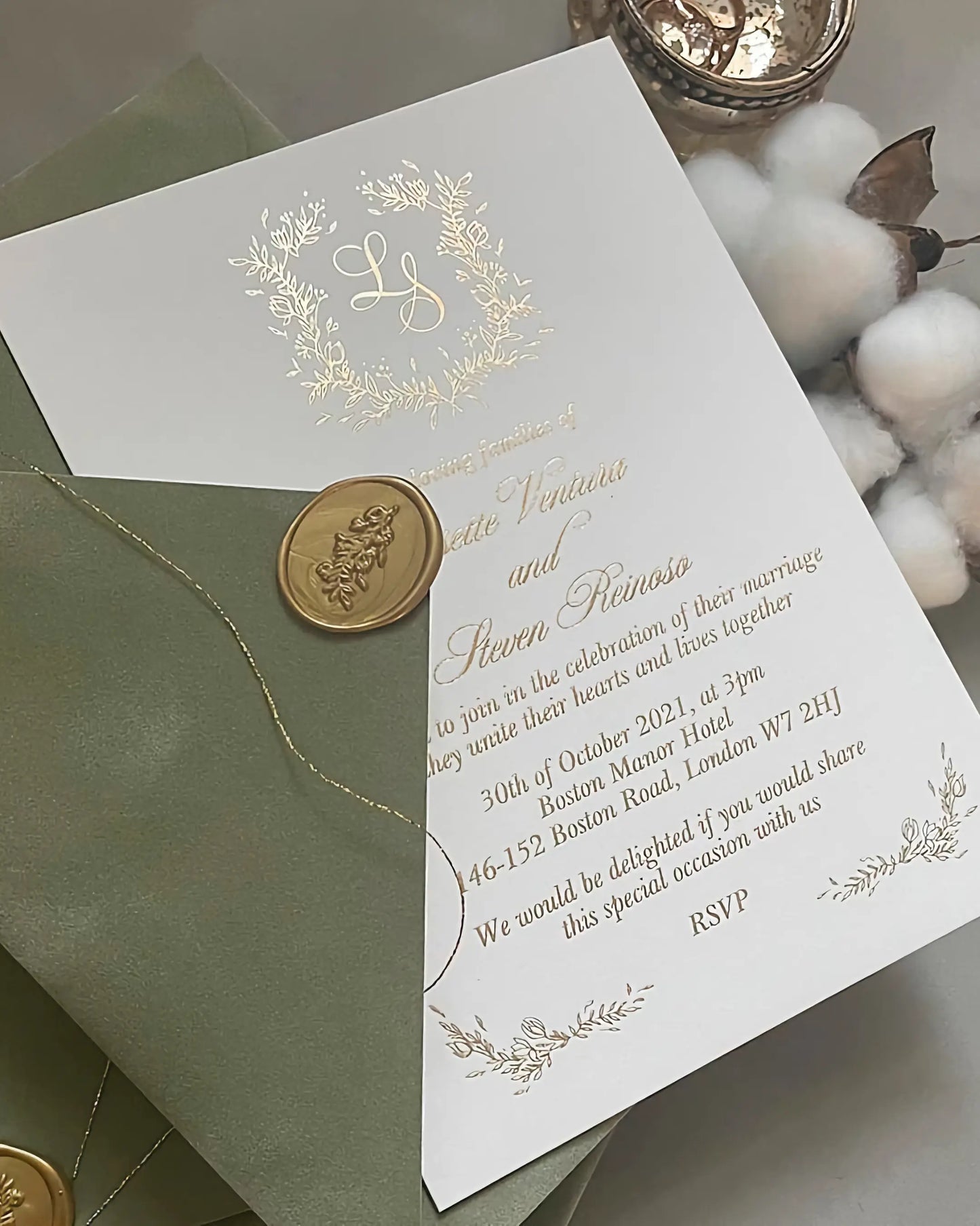 Fiori Gold foil pressed wedding invitation displayed with a sage green envelope, gold thread, and wax seals on a textured background — Polina Perri