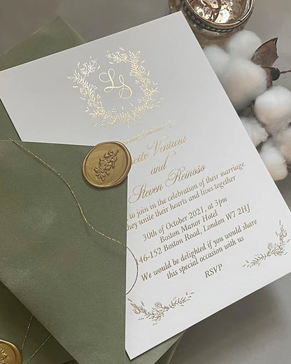 Fiori Gold foil pressed wedding invitation displayed with a sage green envelope, gold thread, and wax seals on a textured background — Polina Perri