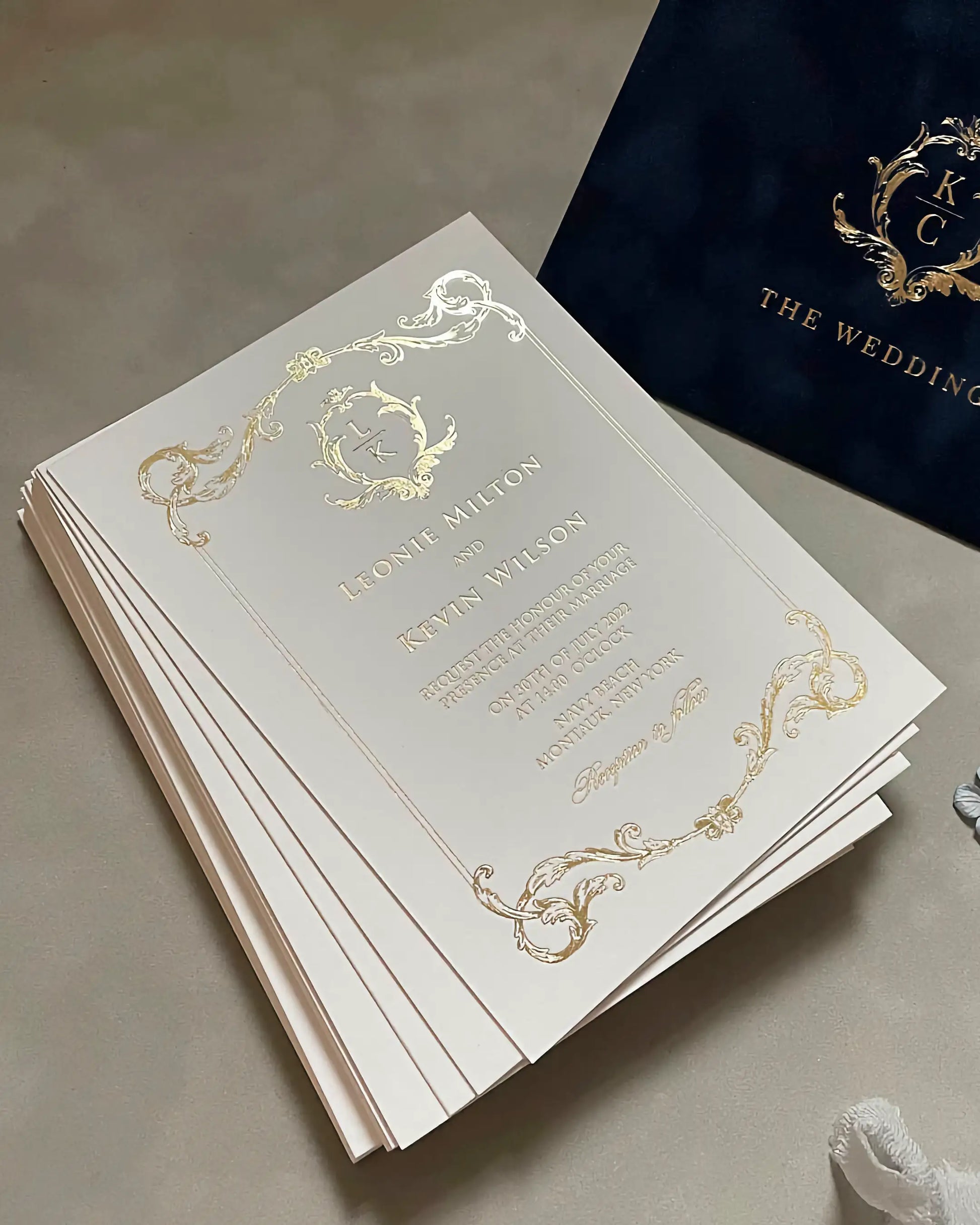 A stack of luxury Isabelle wedding invitations showcasing the premium thickness and tactile quality of the 600gsm cotton card stock with gold foiled edges — Polina Perri
