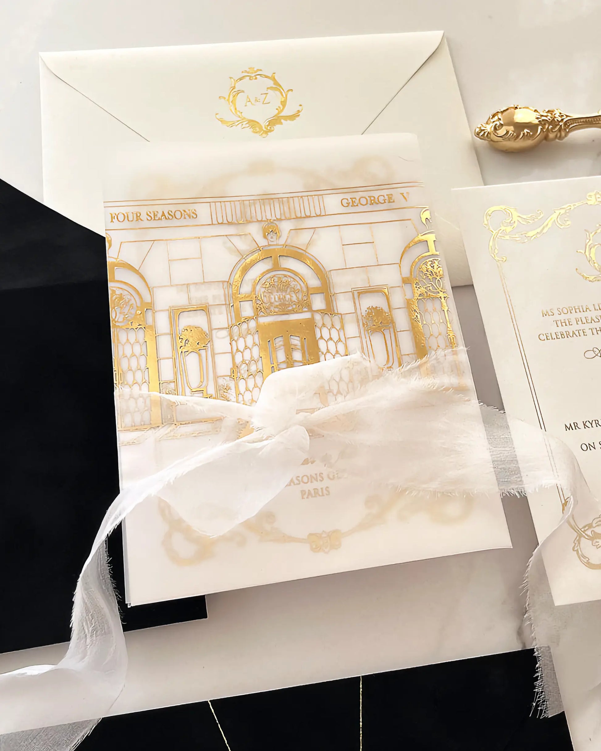 The Isabelle wedding invitation suite showcases the gold-printed architectural vellum wrap beautifully combined with a frayed edge white silk ribbon — Polina Perri