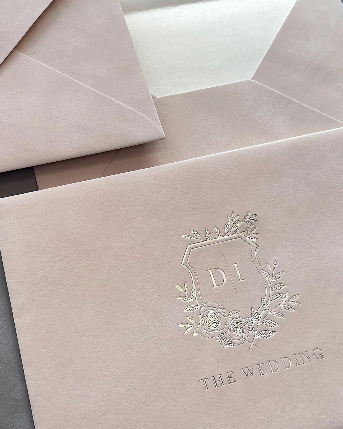 Blush Velvet Paper Envelope close-up with blind embossed floral monogram crest — Polina Perri