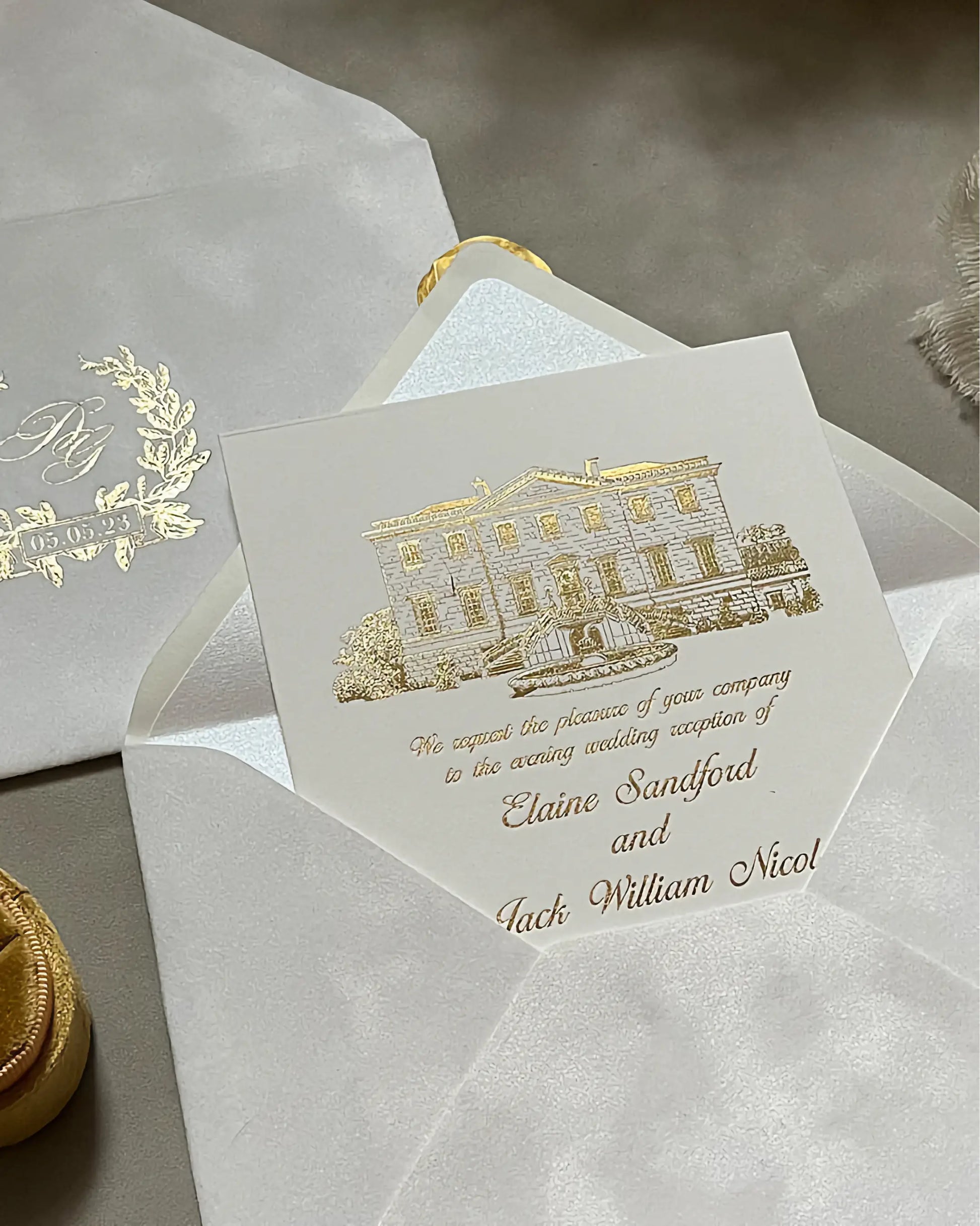 Angled shot of a luxury venue wedding invitation for Botleys Mansion, showing the reflective quality of gold foil stamping on thick ivory cotton stock — Polina Perri