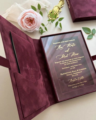 Full layout of an open maroon velvet wedding invitation box with an integrated velvet pocket on the left side and a gold foil stamped acrylic card on the right — Polina Perri