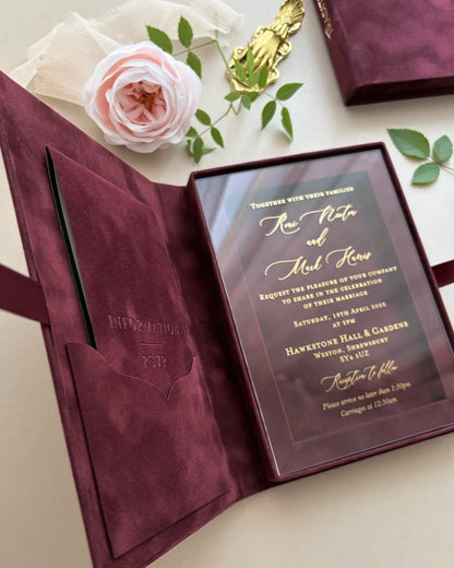 Full layout of an open maroon velvet wedding invitation box with an integrated velvet pocket on the left side and a gold foil stamped acrylic card on the right — Polina Perri