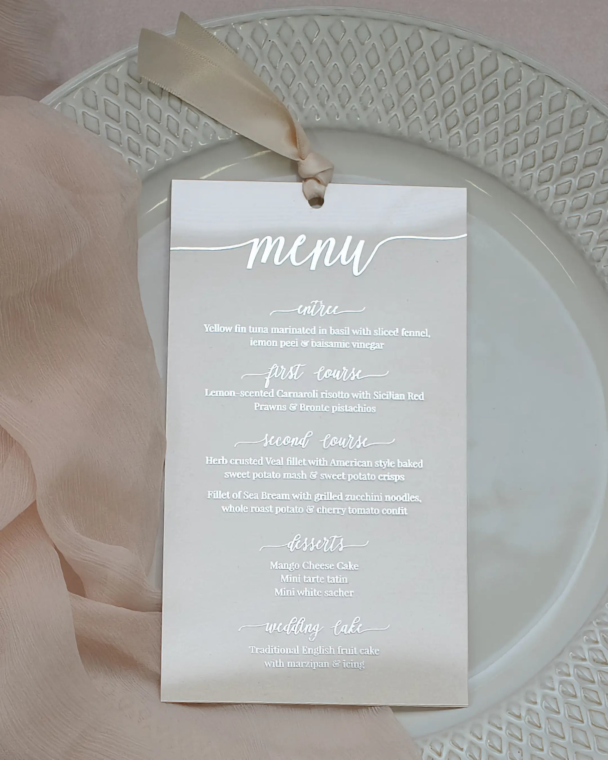 A chic minimalist wedding menu printed in metallic silver foil on crystal clear acrylic, beautifully styled with a soft silk ribbon and a textured white plate — Polina Perri