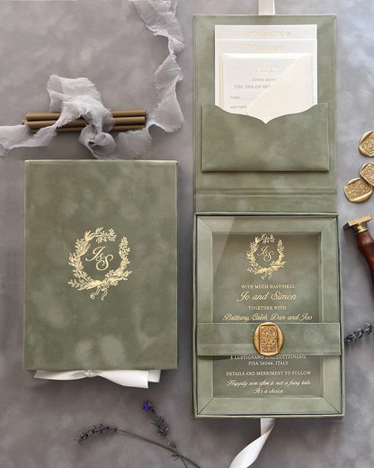 Sage Green Velvet Boxed Wedding Invitations open with clear acrylic insert, matching envelopes, and gold foil monogram detailing on a grey background — Polina Perri