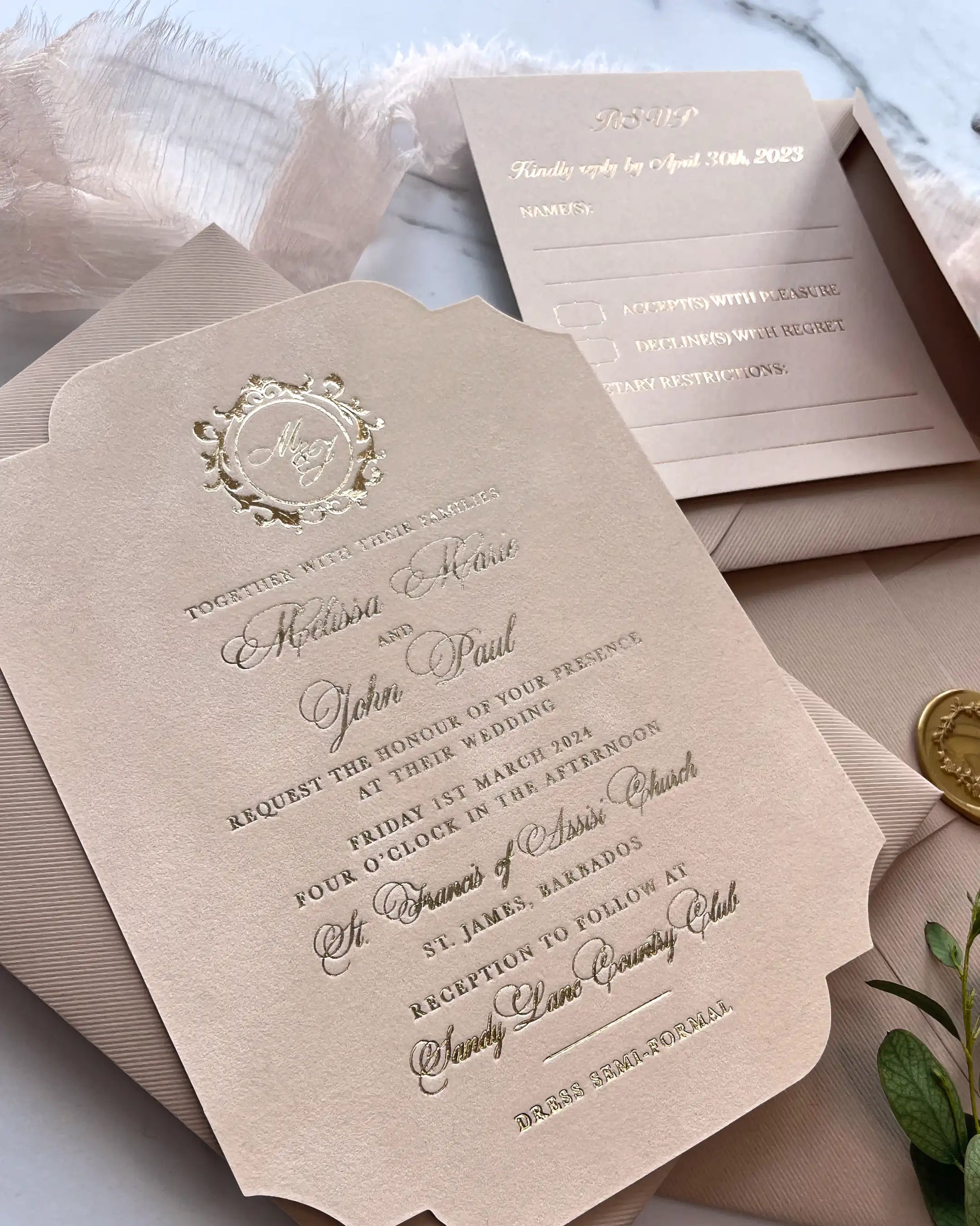 Close-up perspective of a vintage blush pink velvet wedding invitation displaying elegant gold foil typography, custom venue wording, and a matching envelope spine — Polina Perri