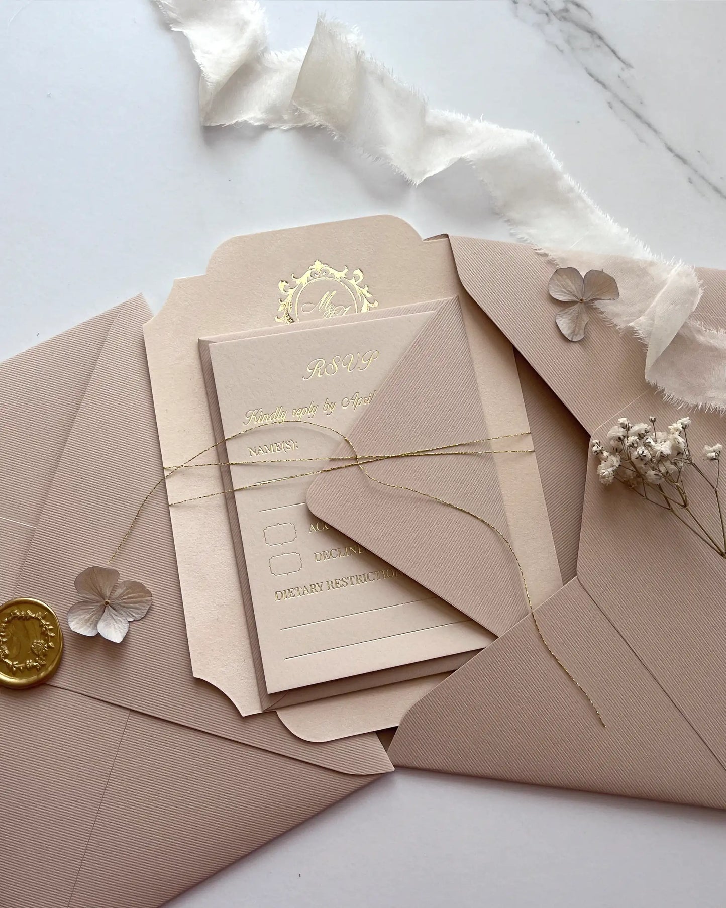Blush pink velvet wedding invitation card bundled with enclosure inserts using a delicate gold thread tie inside an open ribbed paper envelope — Polina Perri