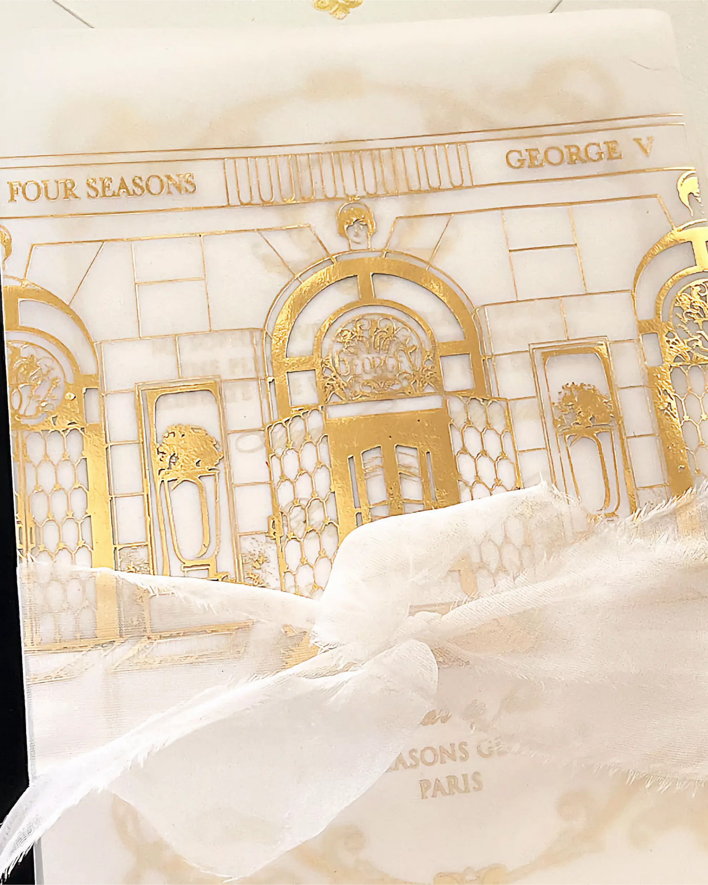 Decorative box with gold architectural design and 'Four Seasons George V' branding.