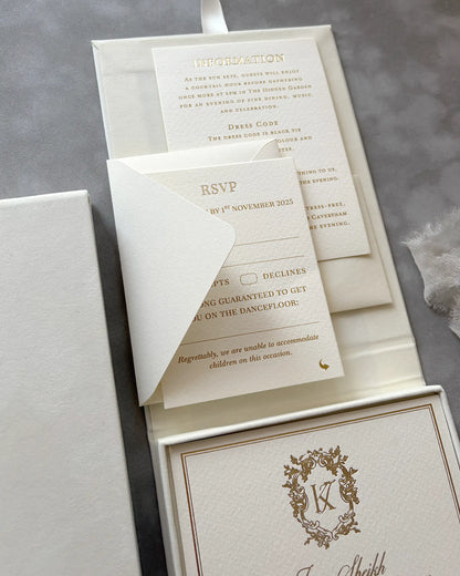 Detailed shot of the wedding RSVP card and matching reply envelope with gold foil details nestled into a cream velvet presentation box — Polina Perri