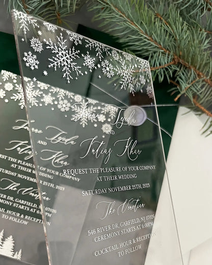 Winter Wonderland Silver Acrylic wedding invitations with silver snowflakes stacked with pine greenery — Polina Perri